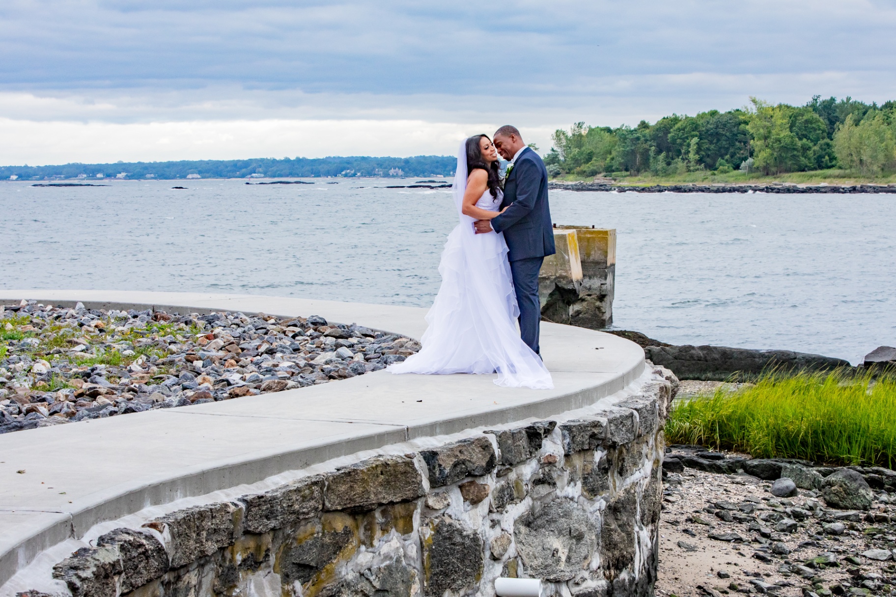 Wedding couple embracing by the waterfront